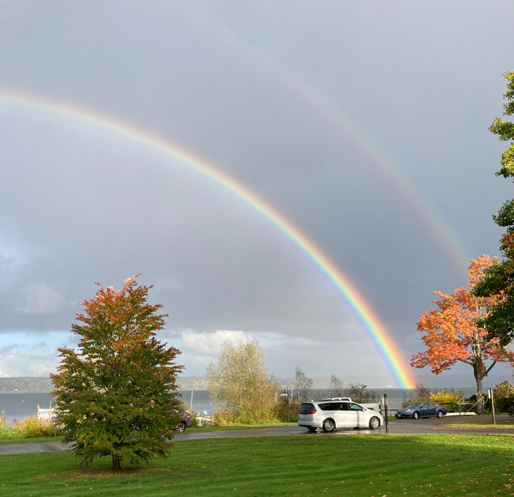 Photo image of a double rainbow over the lake